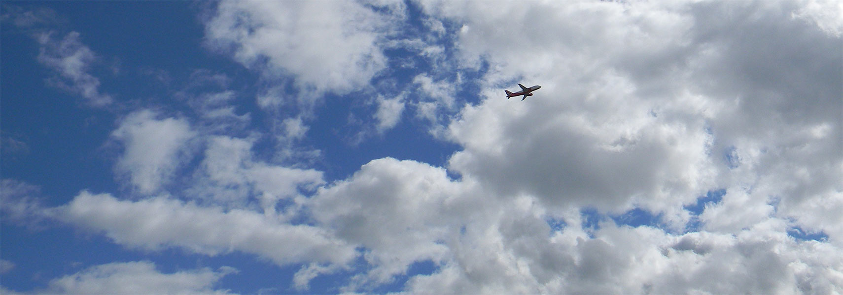 Departing airplane in the sky with clouds