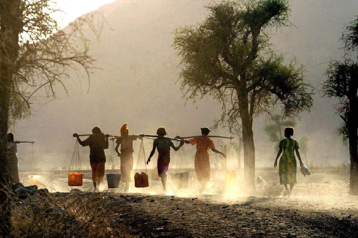 Eritrean Girls carry water on carrying poles