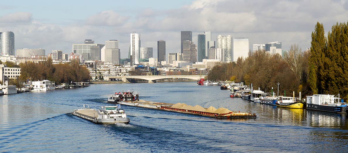 Barges on the Seine river, with the Central Business District of Paris in the background