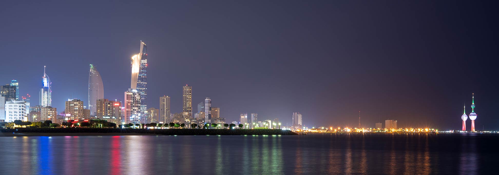 Panorama of Kuwait City at night, with Al Hamra Tower and Kuwait Towers, Kuwait