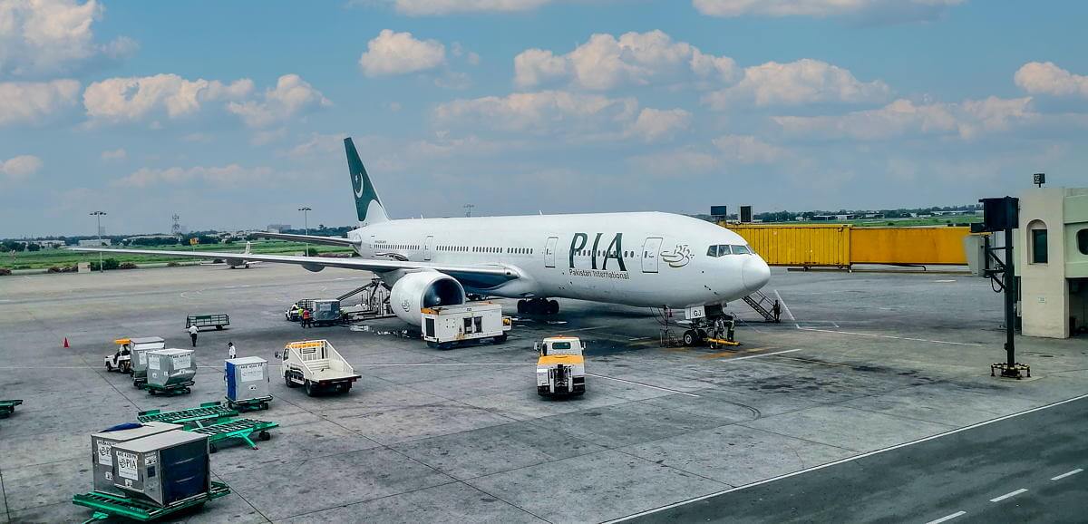 A Pakistan International Airlines Boeing 777-200LR boarding at Allama Iqbal International Airport in Lahore.